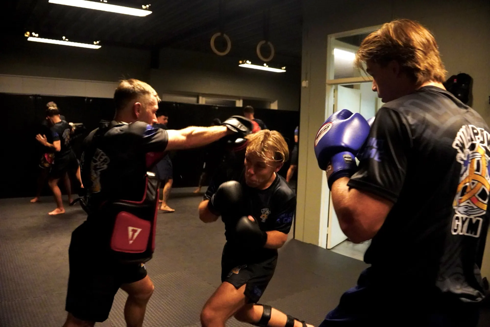 Coach houdt de pads vast voor een lid tijdens een persoonlijke training