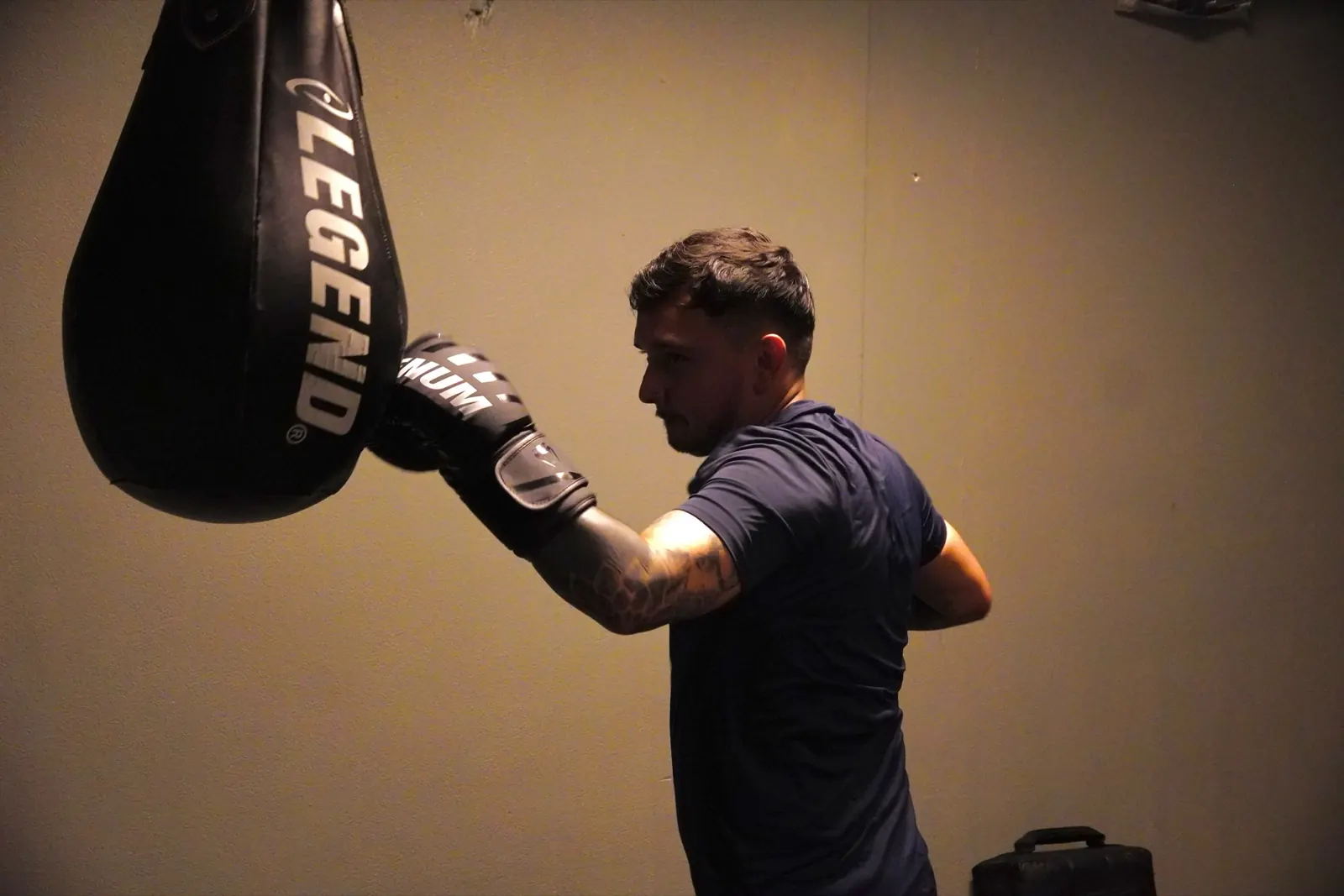 Lid slaat een uppercut op de zware zak tijdens de training